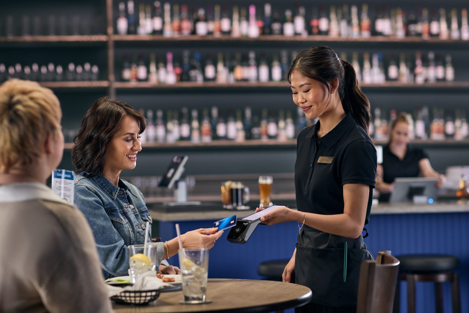 Guest tapping a card on a Genius Handheld