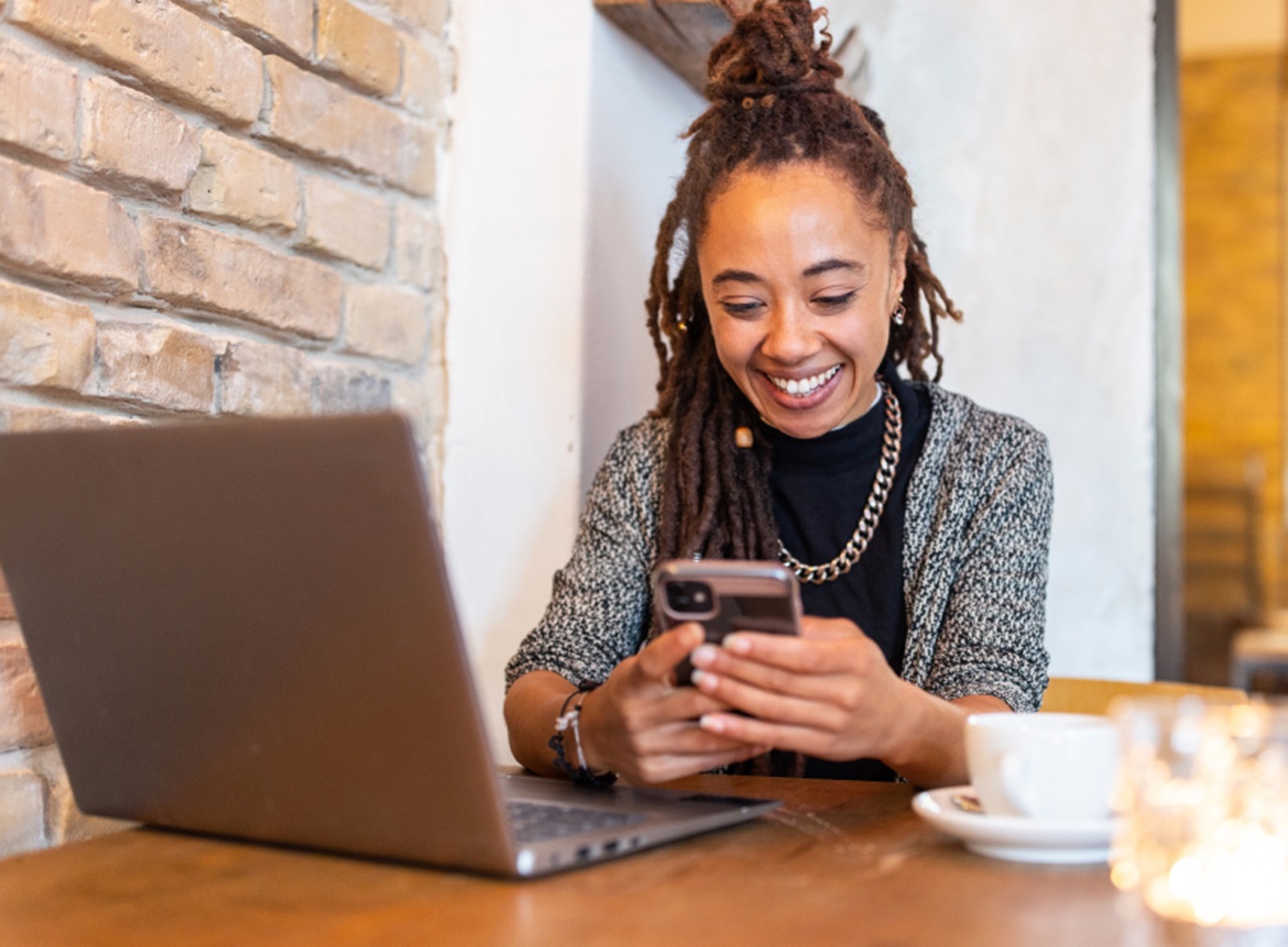 A restaurant owner checks her sales numbers on a laptop at a cafe table