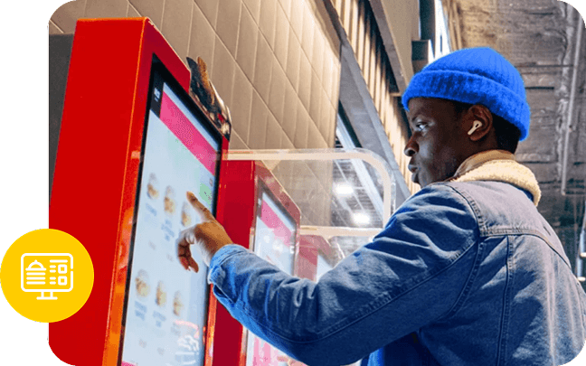 A guest in a blue beanie selecting a food item on a self-ordering kiosk