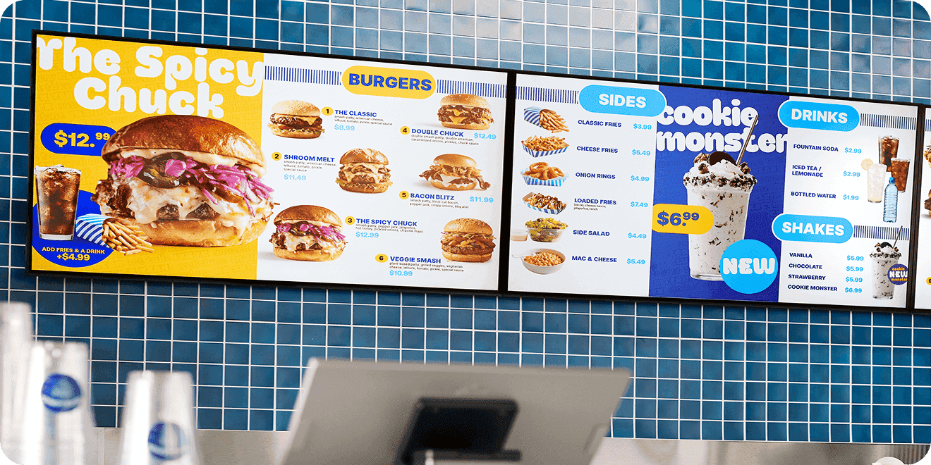 Digital menu boards above a fast-food counter