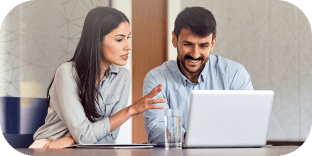 Two colleagues reviewing figures on a laptop