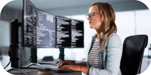 A developer working at a multi-screen desk